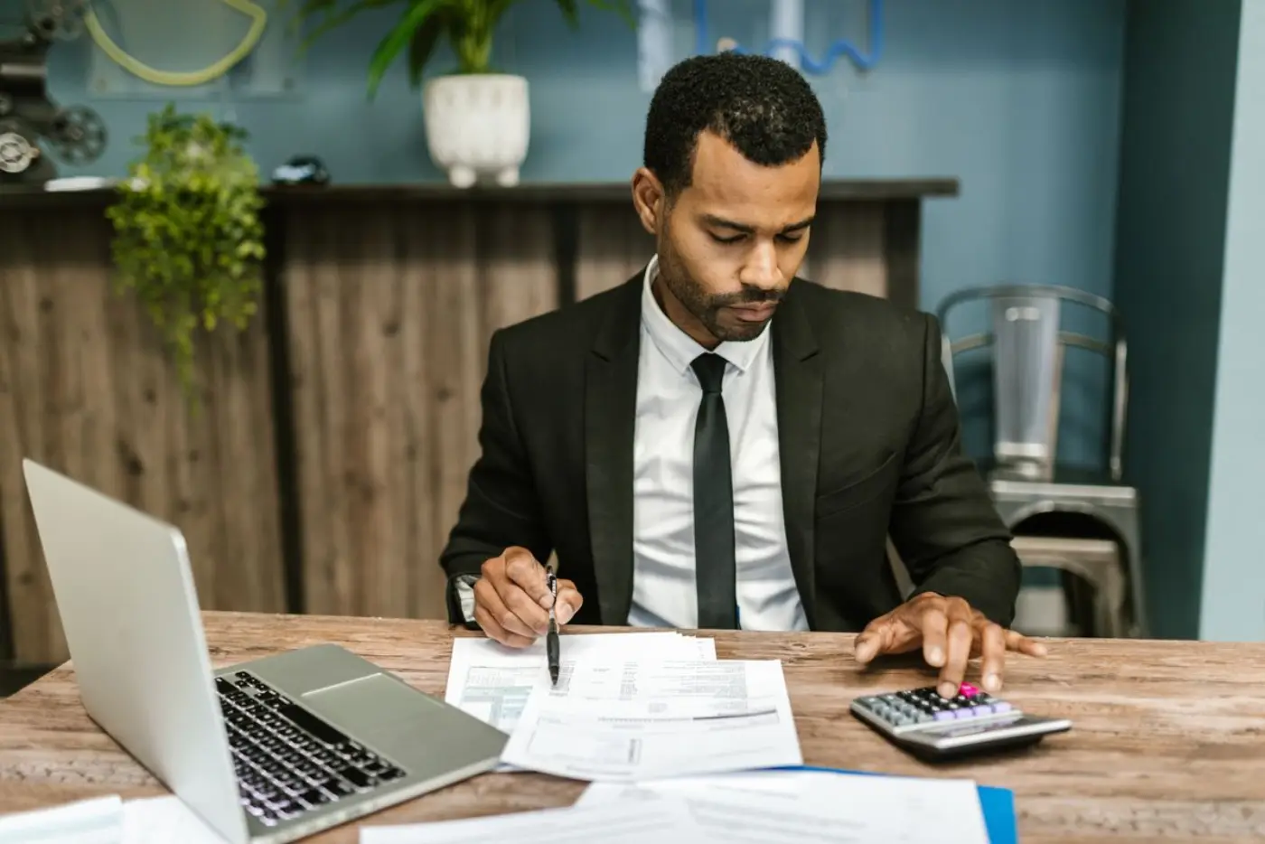A man reviews paperwork at a wooden desk